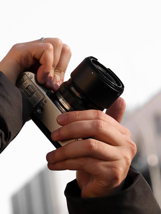 Zwei Hände, die eine Fotokamera halten